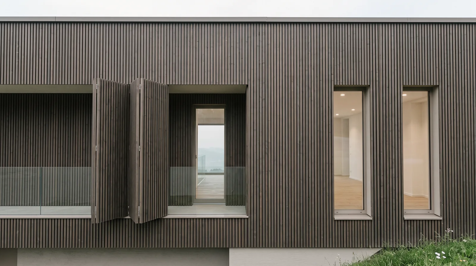 Haus K1: Holzlamellenfassade mit Faltläden